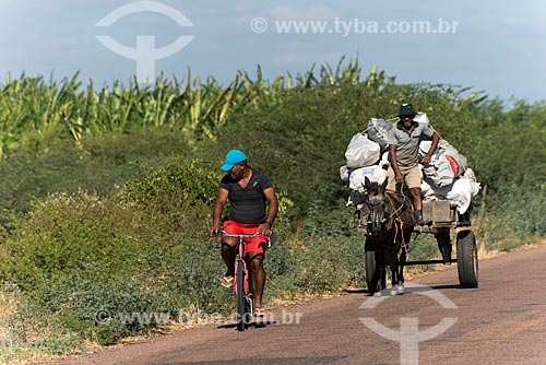  Cyclist and truka indigenous carrying coal in wagon -Truka tribe  - Cabrobo city - Pernambuco state (PE) - Brazil