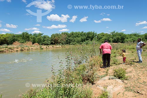  Man feeding fish - pisciculture tank - Caatinga Grande Village - Truka tribe  - Cabrobo city - Pernambuco state (PE) - Brazil