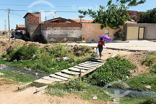  Woman crossing wooden bridge over open sewage - Cabrobo inner city  - Cabrobo city - Pernambuco state (PE) - Brazil