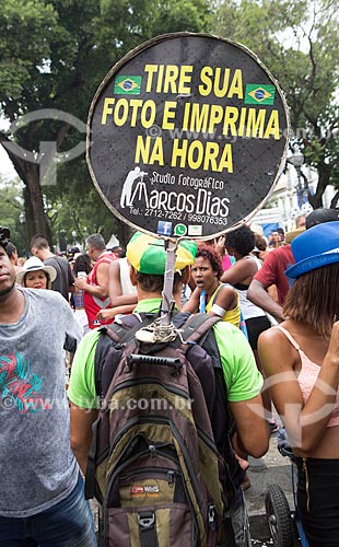  Photographer with plaque offering yours services during Cordao do Bola Preta carnival street troup parade  - Rio de Janeiro city - Rio de Janeiro state (RJ) - Brazil