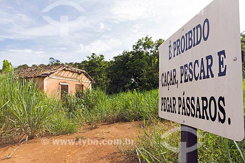  Plaque that say: It is forbidden to hunt, fish and catch birds - Guarani city rural zone with abandonment house in the background  - Guarani city - Minas Gerais state (MG) - Brazil