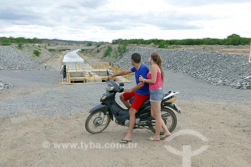  Couple in motorcycle observing irrigation canal of the Project of Integration of Sao Francisco River with the watersheds of Northeast setentrional  - Monteiro city - Paraiba state (PB) - Brazil