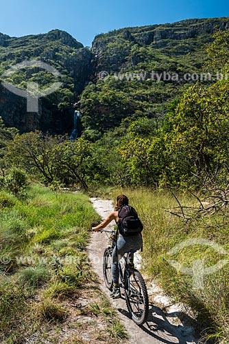  Woman riding bicycles - Serra do Cipo National Park with the Farofa Waterfall in the background  - Santana do Riacho city - Minas Gerais state (MG) - Brazil
