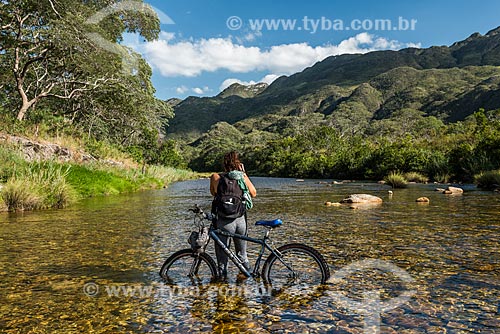  Cyclist crossing and photographing the Mascates River - Serra do Cipo National Park near to Bandeirinhas Canyon  - Santana do Riacho city - Minas Gerais state (MG) - Brazil