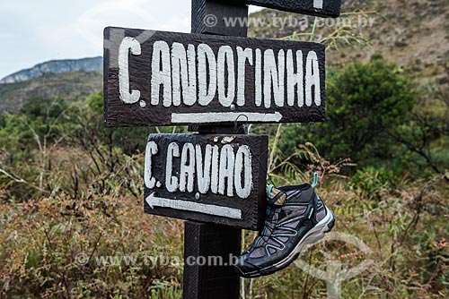  Detail of tennis dried on a trail board in the Serra do Cipo National Park indicating the directions to the Andorinhas Waterfall (on the right) and the Gaviao Waterfall (on the left)  - Jaboticatubas city - Minas Gerais state (MG) - Brazil