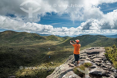  Man photographing the landscape from trail - Mantiqueira Mountain Range - Itatiaia National Park with the Aiuruoca River in the background  - Itatiaia city - Rio de Janeiro state (RJ) - Brazil
