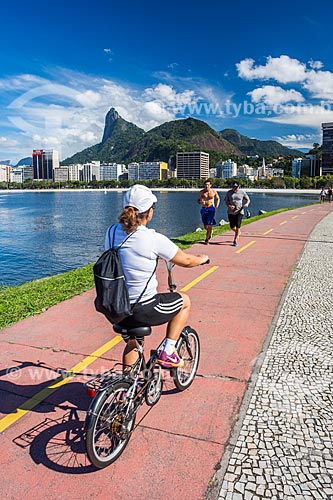  Cyclist on bike lane of the Botafogo Beach with the Christ the Redeemer (1931) in the background  - Rio de Janeiro city - Rio de Janeiro state (RJ) - Brazil
