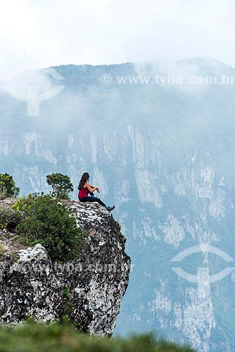 Young woman sitting on the edge of a rock - Fortaleza Canyon - Aparados da Serra National Park  - Cambara do Sul city - Rio Grande do Sul state (RS) - Brazil