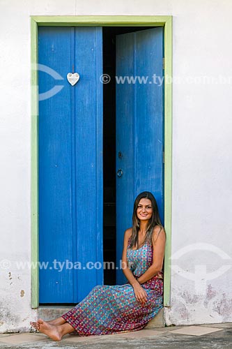  Detail of young woman sitting opposite to door  - Guarani city - Minas Gerais state (MG) - Brazil