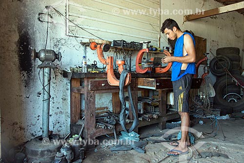  Man repairing car tire hole  - Floresta city - Pernambuco state (PE) - Brazil