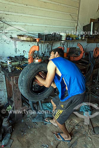  Man repairing car tire hole  - Floresta city - Pernambuco state (PE) - Brazil