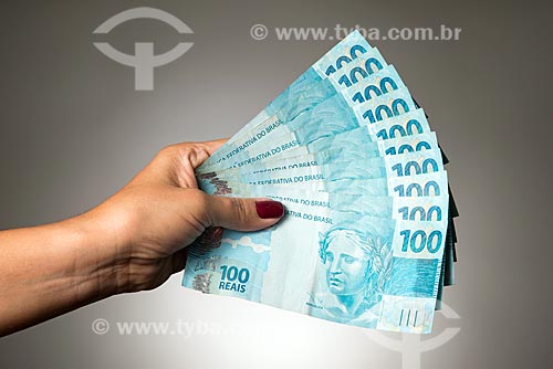  Hand holding banknotes of 100 real  - Rio de Janeiro city - Rio de Janeiro state (RJ) - Brazil