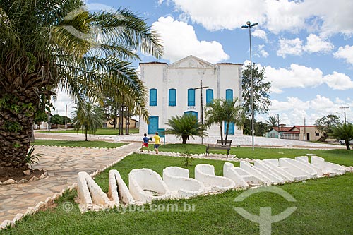  Placard that says: Mossâmedes - Damiana da Cunha Municipal Square - with the Matriz Church of Sao Jose in the background  - Mossamedes city - Goias state (GO) - Brazil