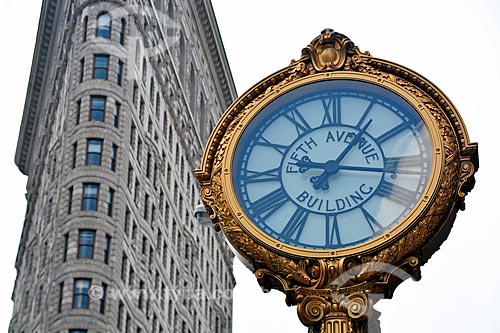  Detail of clock with the Flatiron Building (1902) - also known as Fuller Building - crossroads of Brodway and Madison Square - in the background  - New York city - New York - United States of America