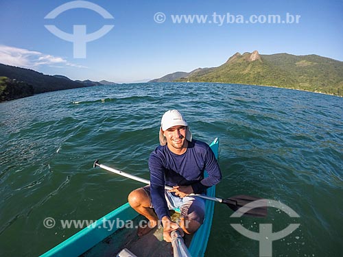  Man making a selfie in kayak - Cruzeiro Beach waterfront with the Sugarloaf Peak - also known as Mamangua Peak - in the background  - Paraty city - Rio de Janeiro state (RJ) - Brazil