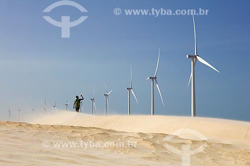  Man walking - dunes of the Parnaiba Delta with the Pedra do Sal Wind Farm (Stone of Salt Wind Farm) in the background  - Ilha Grande city - Piaui state (PI) - Brazil