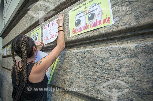  Woman sticking poster during manifestation opposite to Pedro Ernesto Palace (1923) - headquarters of Municipal Chamber of Rio de Janeiro city - against the Rio de Janeiro social security reform  - Rio de Janeiro city - Rio de Janeiro state (RJ) - Brazil
