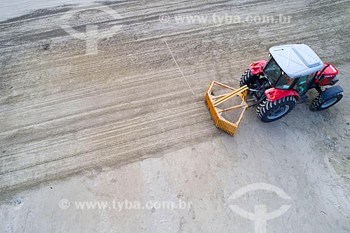  Picture taken with drone of the tractor cleaning the Enseada Beach (Bay Beach) sand  - Bertioga city - Sao Paulo state (SP) - Brazil