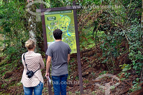  Couple of tourists consulting information plaque with map of the Caracol State Park  - Canela city - Rio Grande do Sul state (RS) - Brazil