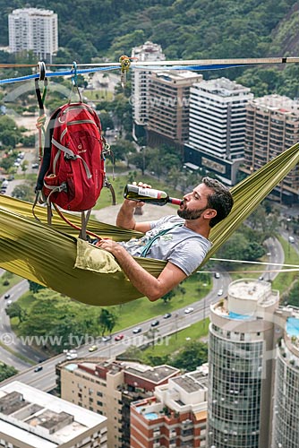  Man lying in a hammock on slackline strip with a bottle of wine - Cantagalo Hill  - Rio de Janeiro city - Rio de Janeiro state (RJ) - Brazil