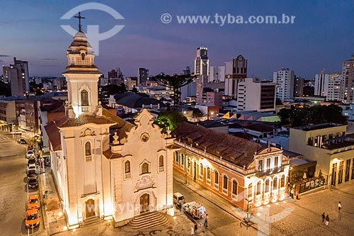  Picture taken with drone of the Our Lady of Rosario de Sao Benedito Church (1946) during the nightfall with buildings from the city center of Curitiba in the background  - Curitiba city - Parana state (PR) - Brazil