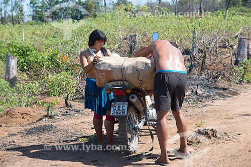 Indigenous couple of Aiha village of the Kalapalo tribe carrying cassava on the motorcycle to transport to the village - INCREASE OF 100% OF THE VALUE OF TABLE  - Querencia city - Mato Grosso state (MT) - Brazil