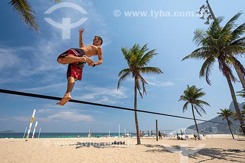  Practitioner of slackline - Ipanema Beach waterfront with the Morro Dois Irmaos (Two Brothers Mountain) in the background  - Rio de Janeiro city - Rio de Janeiro state (RJ) - Brazil