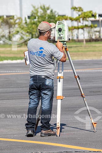  Topographer with topographic station during work - runway of the Laelio Baptista Airport - also known as Marica Airport  - Marica city - Rio de Janeiro state (RJ) - Brazil