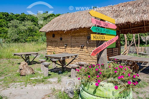  Tables, clay house with thatched roof and bilingual sign plaques - Mata Verde Bonita Village (Tekoa Ka Aguy Ovy Pora) of the Guarani tribe  - Marica city - Rio de Janeiro state (RJ) - Brazil
