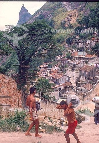  Dweller carrying gas cylinder - Santa Marta slum with the Christ the Redeemer in the background - 90s  - Rio de Janeiro city - Rio de Janeiro state (RJ) - Brazil