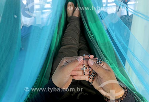  Detail of riverine holding rosary lying in a hammock - recreio - regional boat - Purus River  - Boca do Acre city - Amazonas state (AM) - Brazil