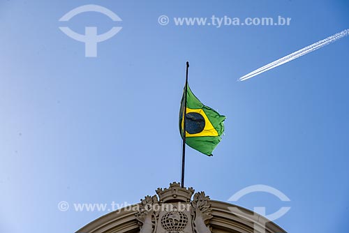  Detail of brazilian flag - Municipal Theater of Rio de Janeiro (1909) with airplane with condensation trail in the background  - Rio de Janeiro city - Rio de Janeiro state (RJ) - Brazil