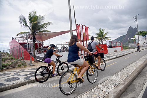  Cyclists in bike lane - Ipanema Beach waterfront with the Morro Dois Irmaos (Two Brothers Mountain in the background  - Rio de Janeiro city - Rio de Janeiro state (RJ) - Brazil