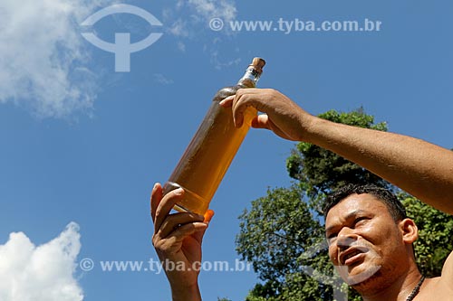  Rural producer holding oil from andiroba (Carapa Guianensis) - known for its cosmetic properties - Bauana Riparian Community  - Carauari city - Amazonas state (AM) - Brazil