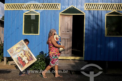  Woman carrying Saint Peters statue and boy carrying Holy Family picture - Bom Jesus Riparian Community  - Carauari city - Amazonas state (AM) - Brazil