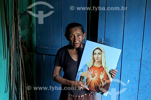  Rural producer from Bauana riparian community - Medio Jurua Extractive Reserve - holding Sacred Heart of Mary picture  - Carauari city - Amazonas state (AM) - Brazil