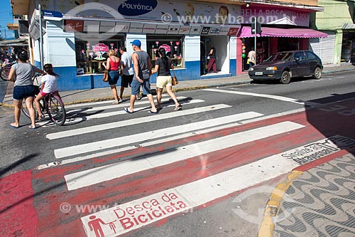  Pedestrians crossing in the pedestrian range - Lane with signs for pedestrians and cyclists - Urban stretch of highway SP-055  - Caraguatatuba city - Sao Paulo state (SP) - Brazil