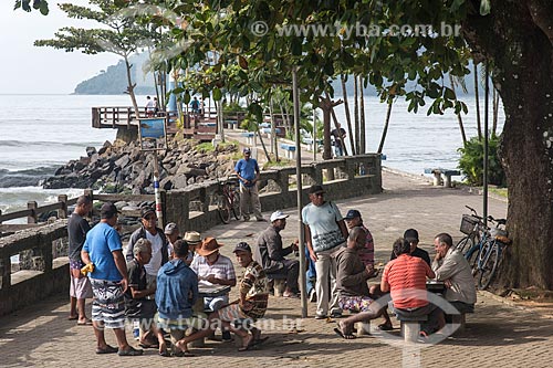  People playing cards in recreation area - mouth of Grande River  - Ubatuba city - Sao Paulo state (SP) - Brazil