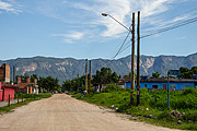  Unpaved street in the residential neighborhood with Serra do Mar mountains in the background  - Bertioga city - Sao Paulo state (SP) - Brazil