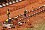  Workers working on laying curb on paved street  - Sao Jose do Rio Preto city - Sao Paulo state (SP) - Brazil