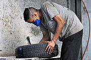  Man working in tire repair shop and wearing mask because of the Coronavirus Crisis  - Mirassol city - Sao Paulo state (SP) - Brazil