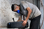  Man working in tire repair shop and wearing mask because of the Coronavirus Crisis  - Mirassol city - Sao Paulo state (SP) - Brazil