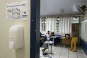 Dispenser with alcohol gel at the entrance to the classroom and high school classroom with distance between chairs and students wearing protective masks because of Covid 19 - Sao Paulo city - Sao Paulo state (SP) - Brazil