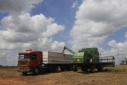 Combine harvester unloading soybeans into bulk truck after harvest - Planalto city - Sao Paulo state (SP) - Brazil