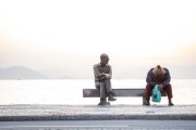 Homeless man sitting on the bench next to the statue of the poet Carlos Drummond de Andrade - Rio de Janeiro city - Rio de Janeiro state (RJ) - Brazil