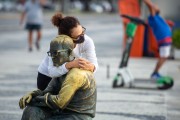 Woman hugging the statue of the poet Carlos Drummond de Andrade on Copacabana Beach - Rio de Janeiro city - Rio de Janeiro state (RJ) - Brazil