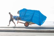 Man pulling cargo trolley - man carrying a cart - with beach chairs - Copacabana Beach waterfront  - Rio de Janeiro city - Rio de Janeiro state (RJ) - Brazil