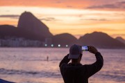 Man photographing with cell phone the sunrise on Copacabana beach with Sugarloaf Mountain in the background. - Rio de Janeiro city - Rio de Janeiro state (RJ) - Brazil