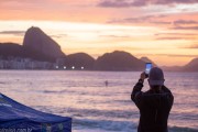 Man photographing with cell phone the sunrise on Copacabana beach with Sugarloaf Mountain in the background. - Rio de Janeiro city - Rio de Janeiro state (RJ) - Brazil