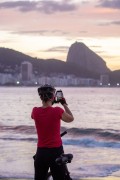 Woman photographing with cell phone the sunrise on Copacabana beach with Sugarloaf Mountain in the background. - Rio de Janeiro city - Rio de Janeiro state (RJ) - Brazil